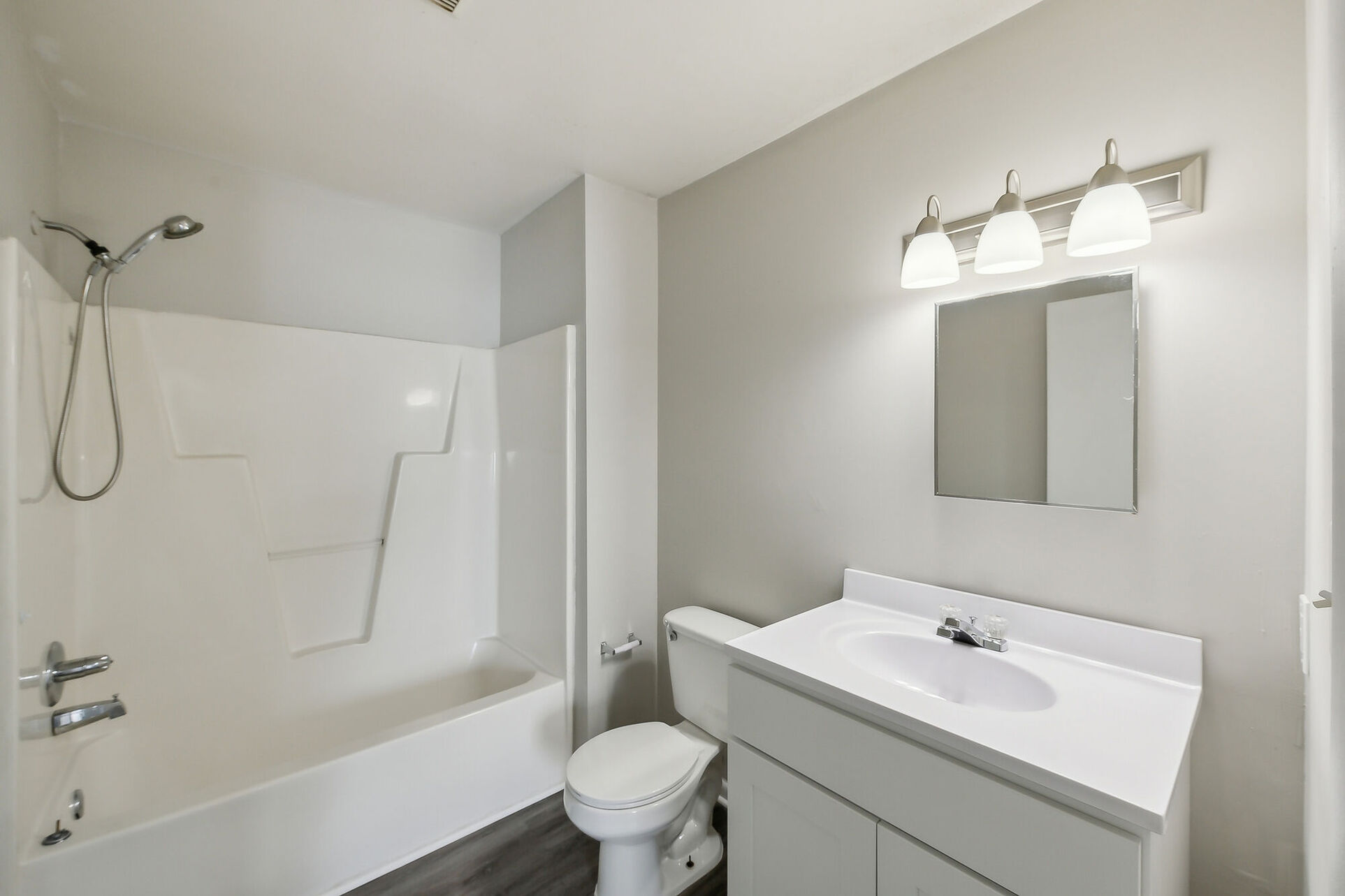 Bathroom with tub and white cabinets