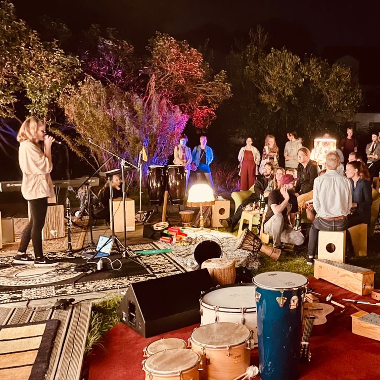 Musikerinnen und Musiker bei einer abendlichen Session im Garten