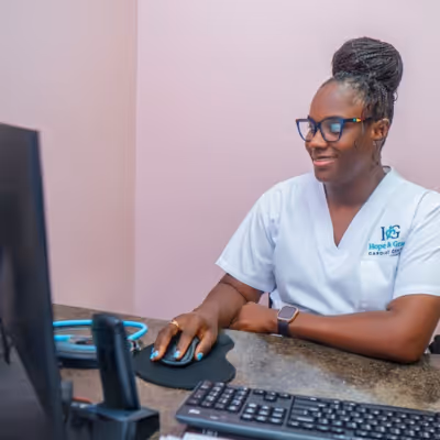 Hope & Grace Cardiac Centre healthcare professional wearing scrubs working on a computer at a desk.