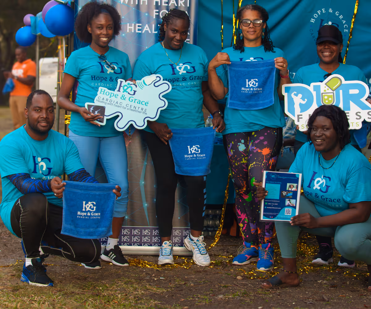 Group of six people in teal Hope & Grace shirts holding branded towels, signs, and flyers outdoors.