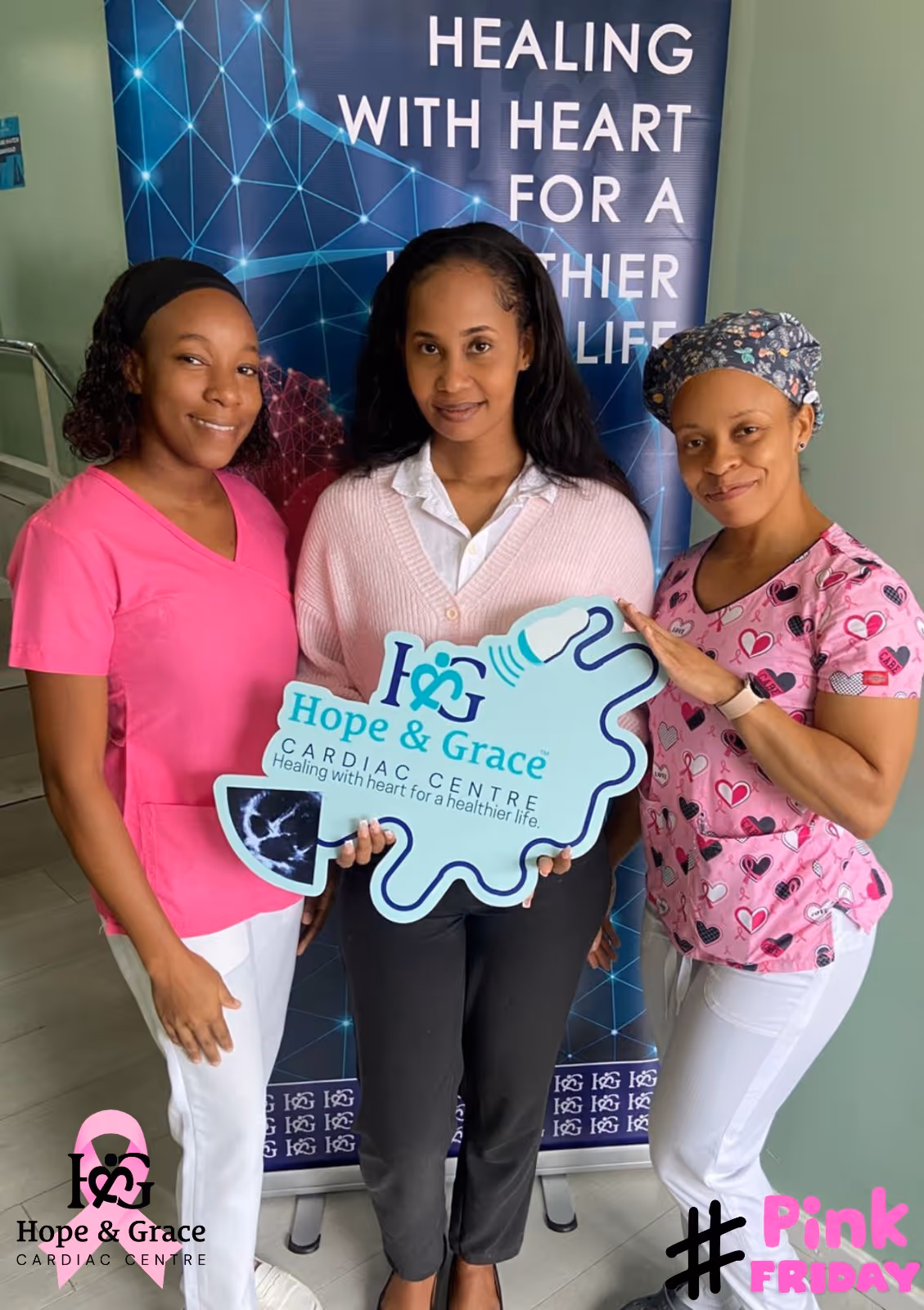 Three women posing, holding Hope & Grace Cardiac Centre sign, promoting Pink Friday breast cancer awareness.