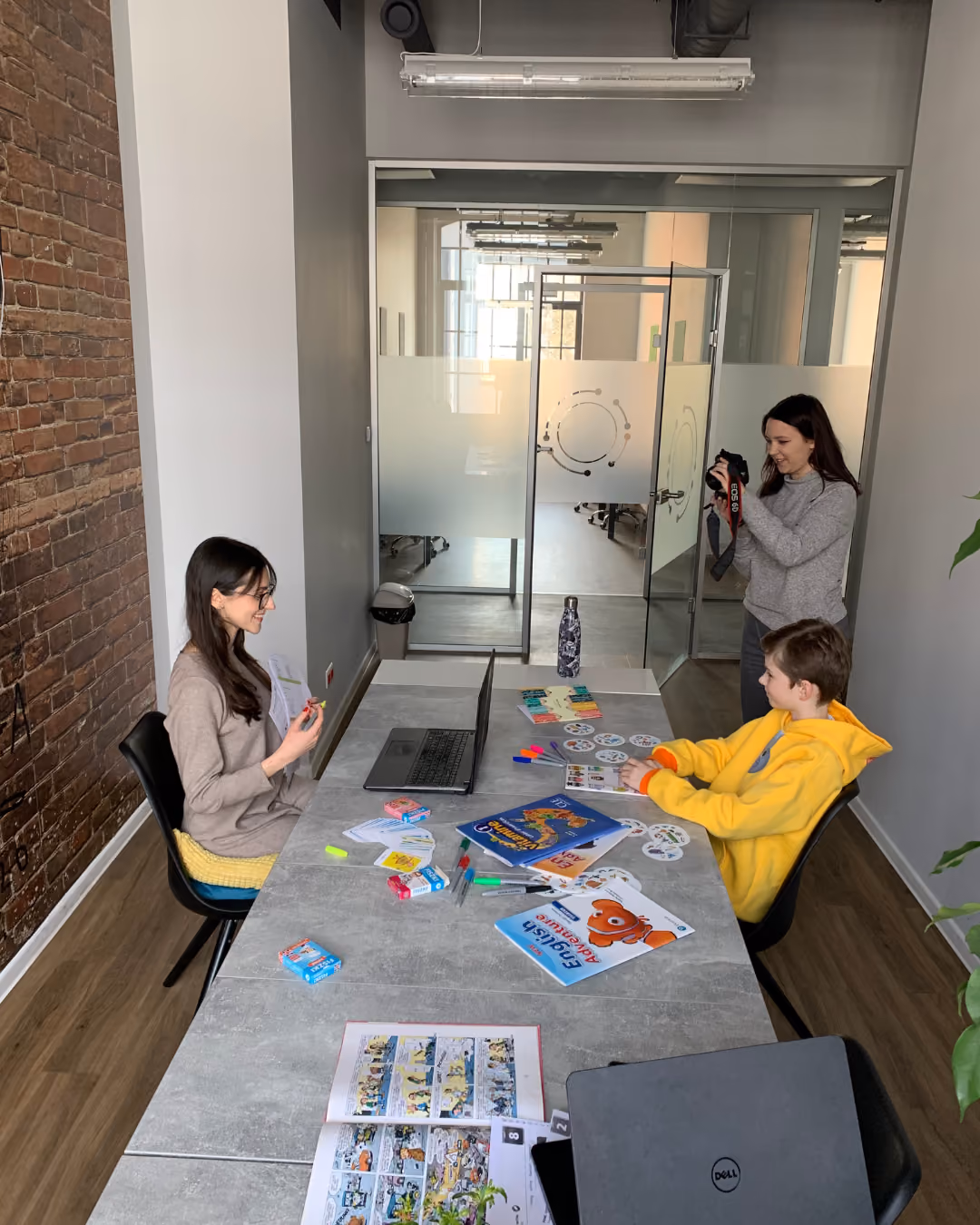 Three people in a modern meeting room with a long table