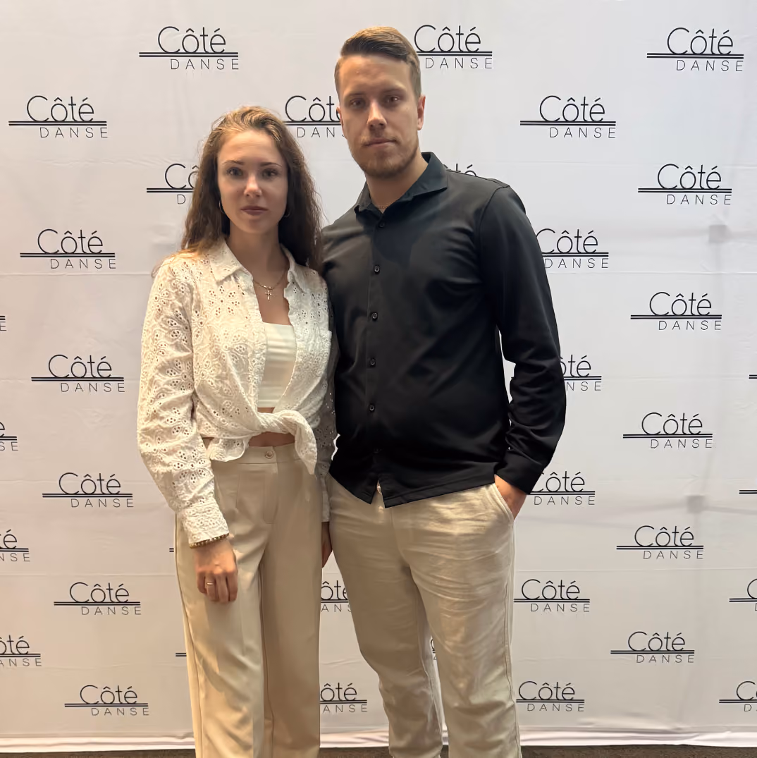 Yaroslav and Kateryna standing side by side in front of a backdrop with repeated 'Côté Danse' logos
