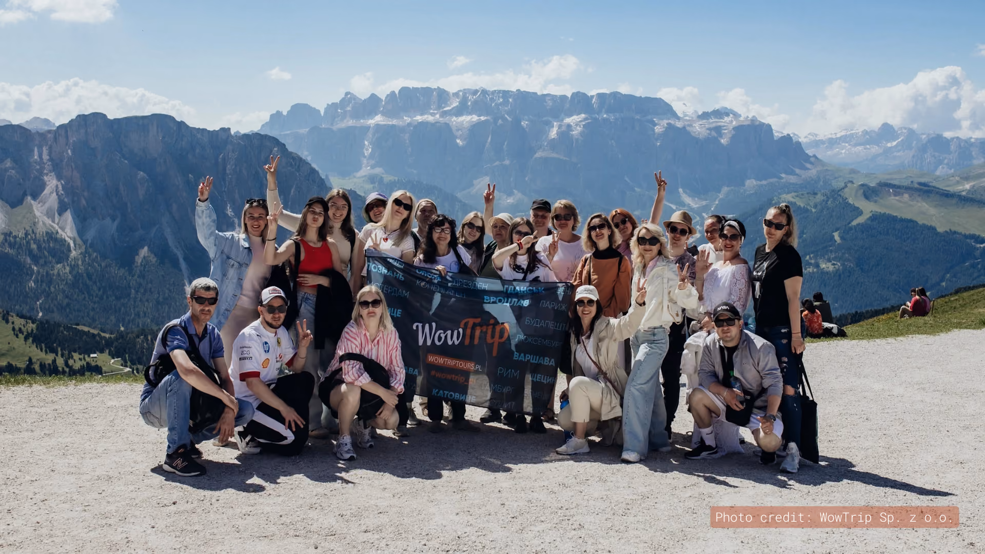WowTrip travelers holding a banner in the mountains
