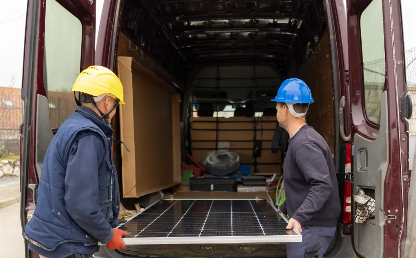 Paneles solares instalados en el techo de una casa moderna bajo un cielo azul con pocas nubes.