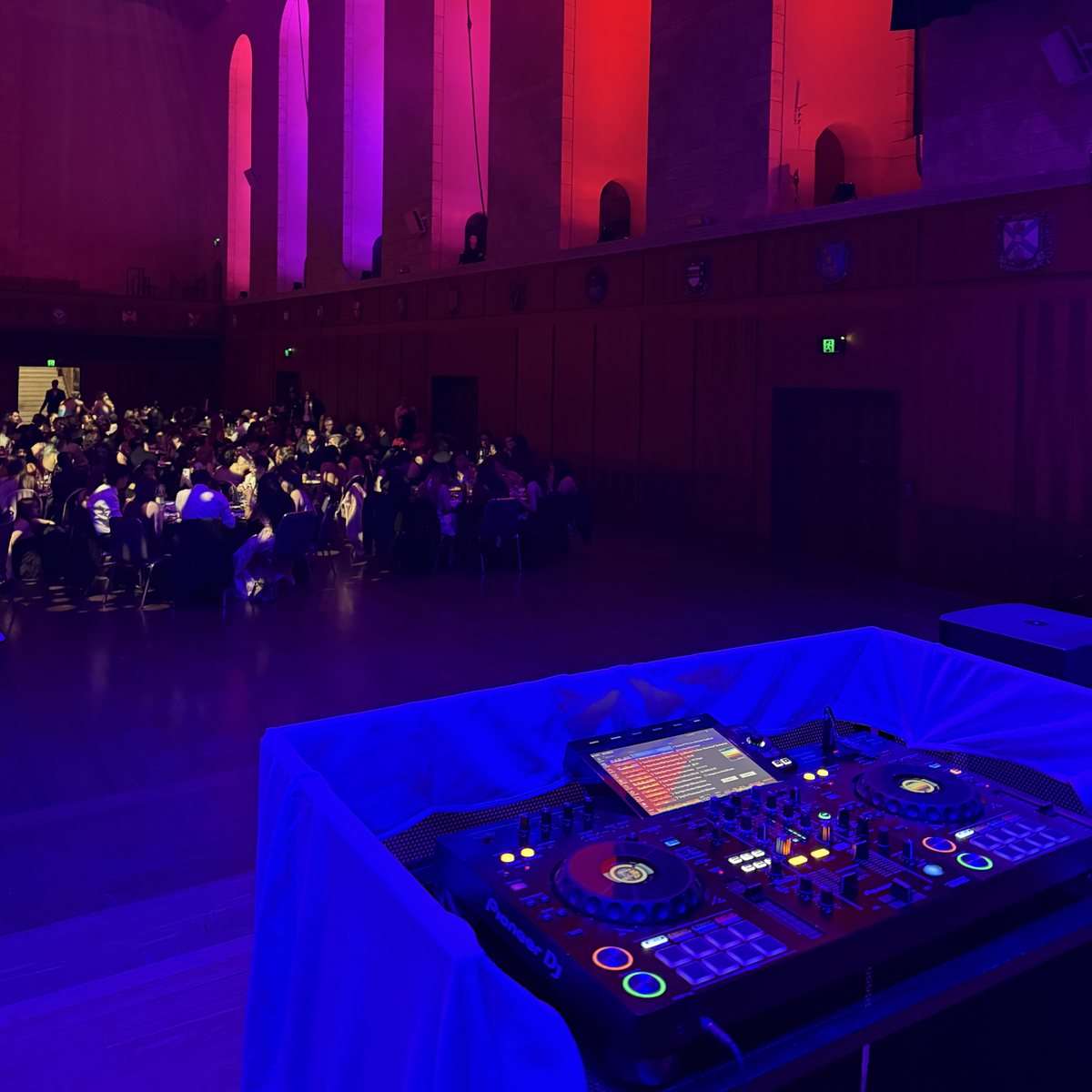 Certified Entertainment DJ booth and Pioneer controller set up at a university ball in Winthrop Hall, UWA, with guests seated behind