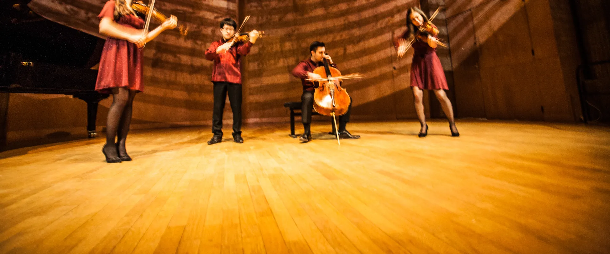 String quartet performing on a wooden concert stage