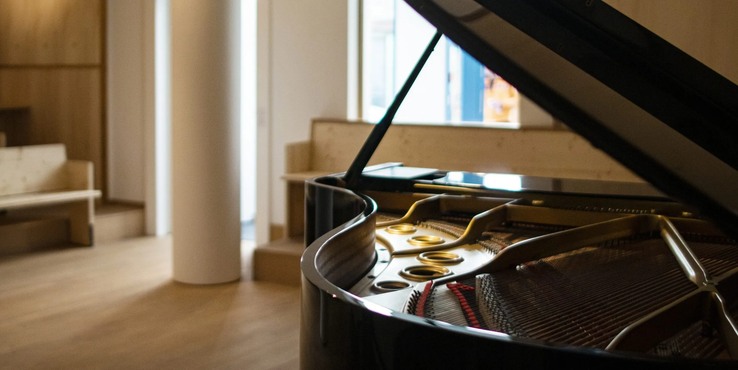 Open grand piano in the wood-panelled concert hall of L’Accord Parfait in Paris