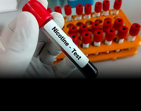 A person in white gloves holding a tube of blood.