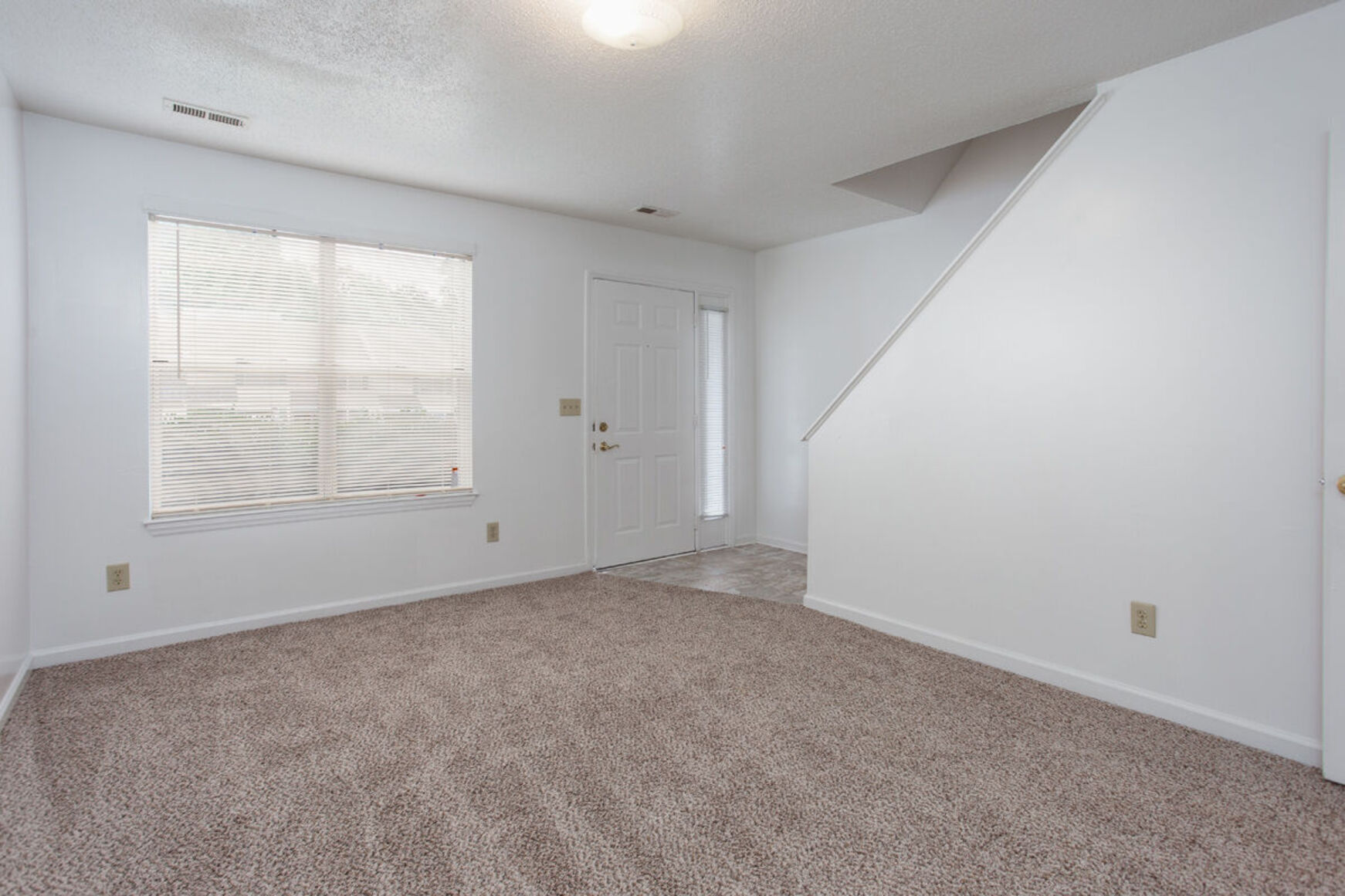 Living room with carpet and stairs