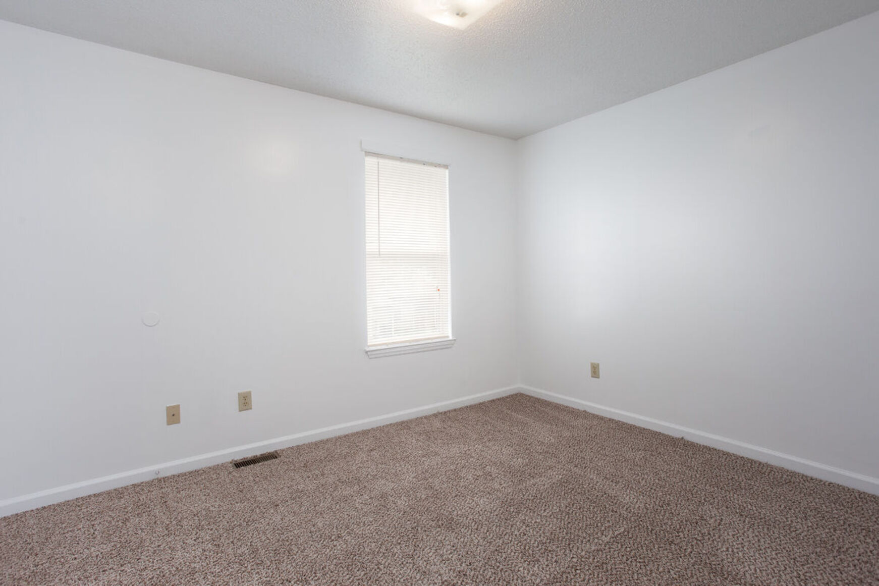 Bedroom with carpet and while walls