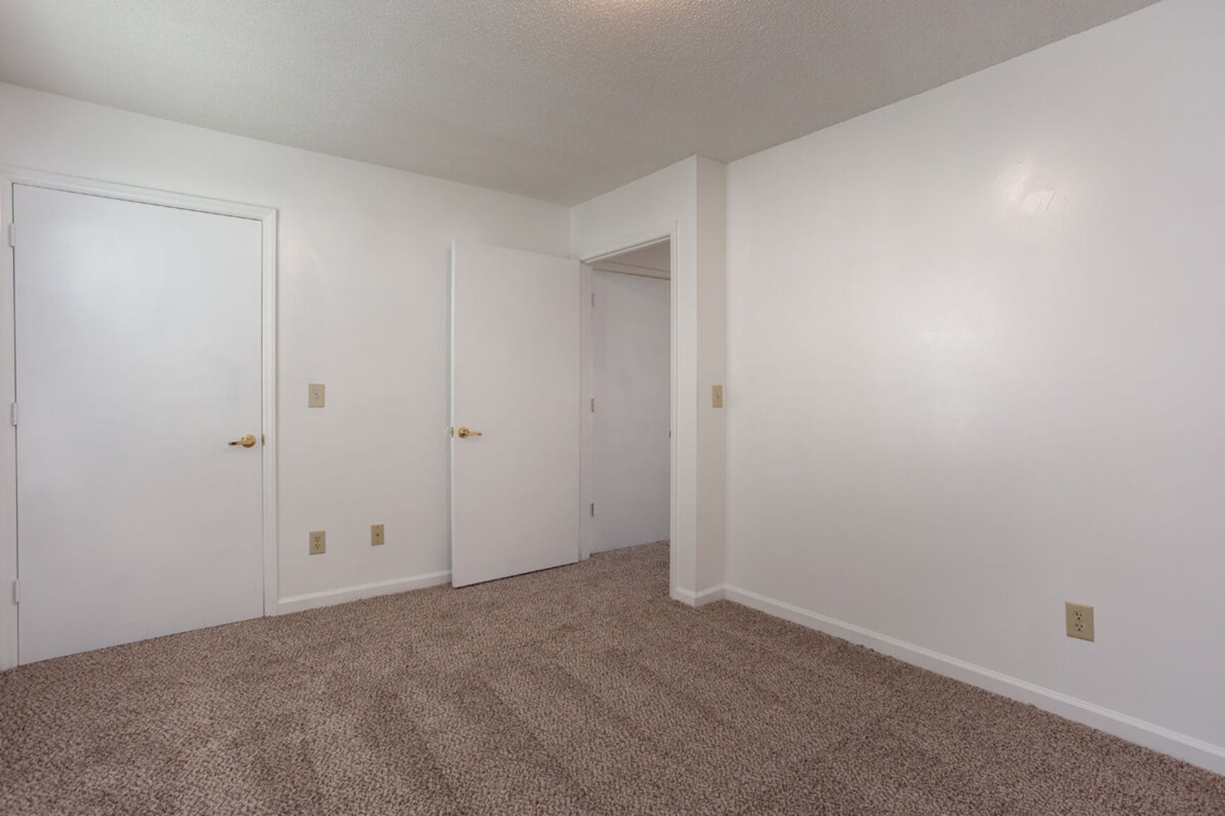 Bedroom with carpet and while walls