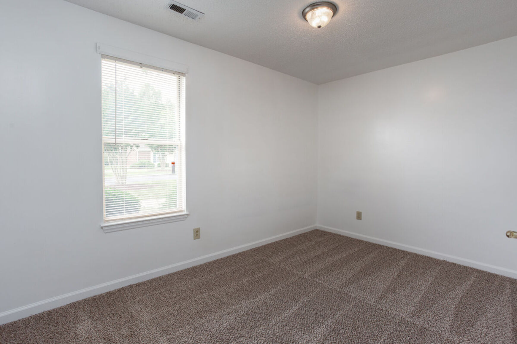 Bedroom with carpet and while walls