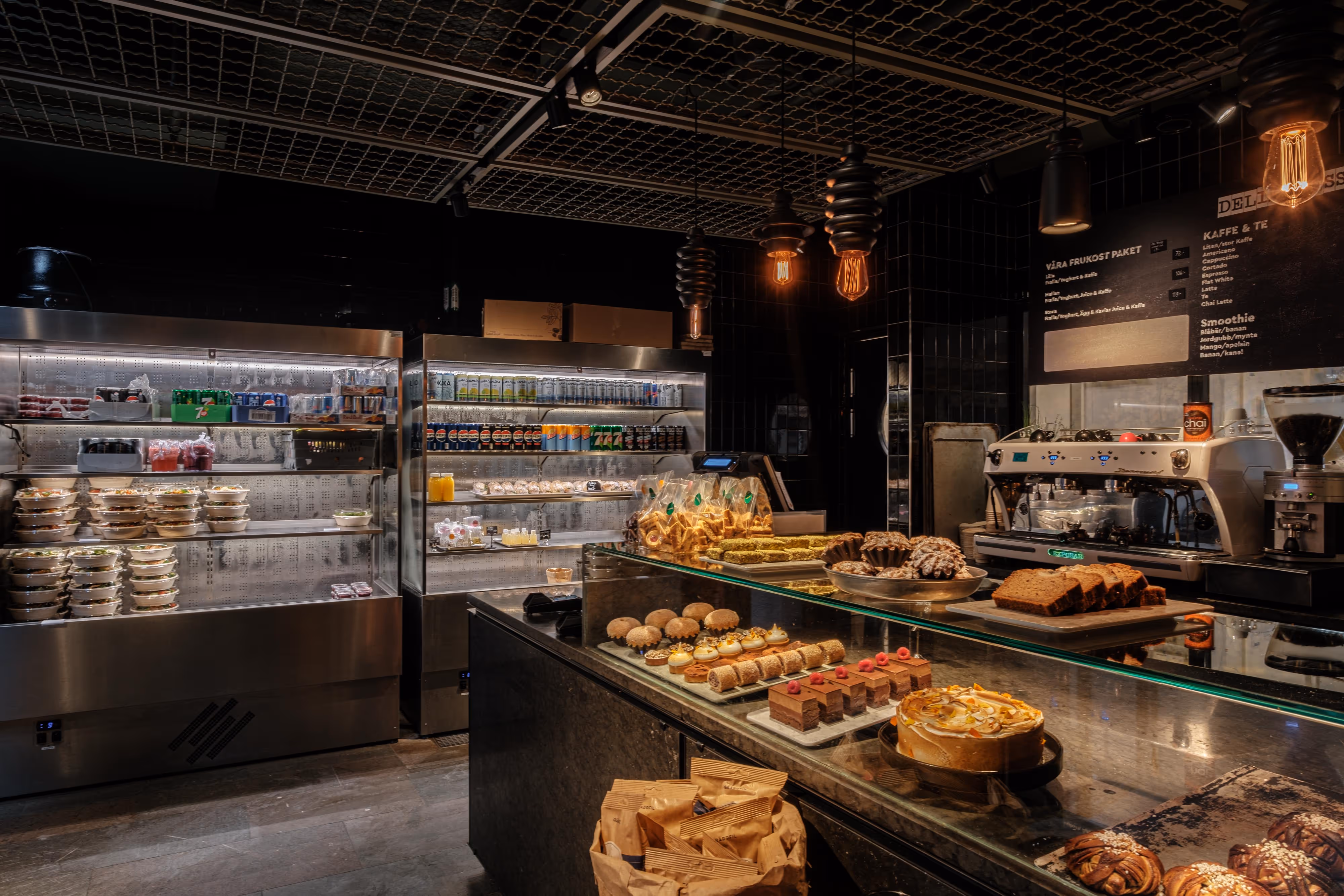 A bakery with a display of pastries and a refrigerator.