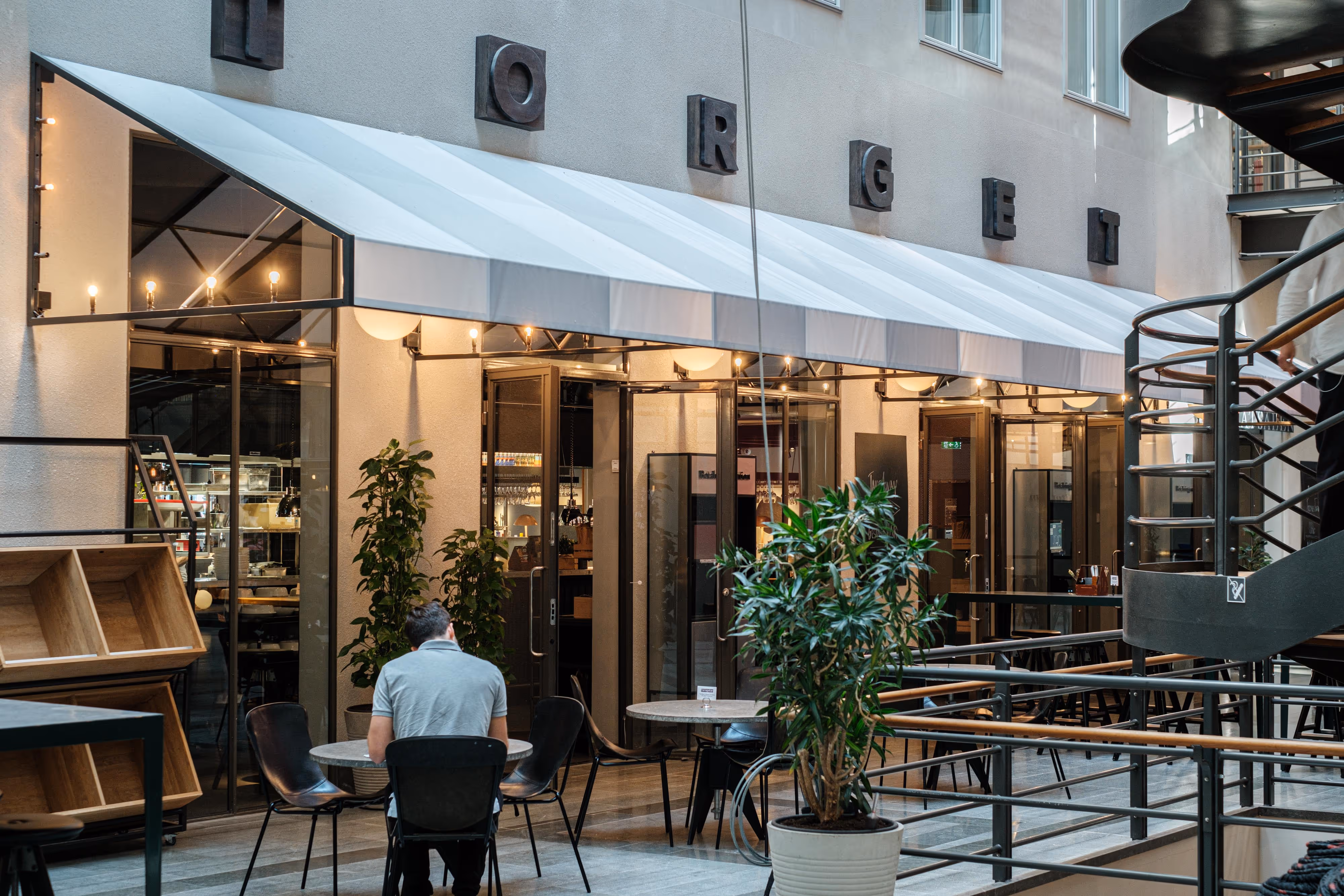 A man sitting at a table outside a restaurant.