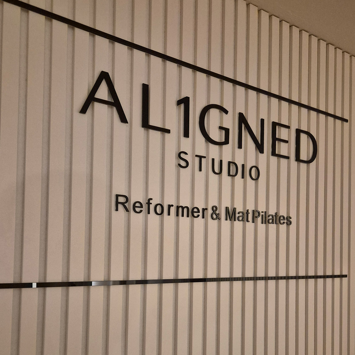 AL1GNED Logo an der Studiowand