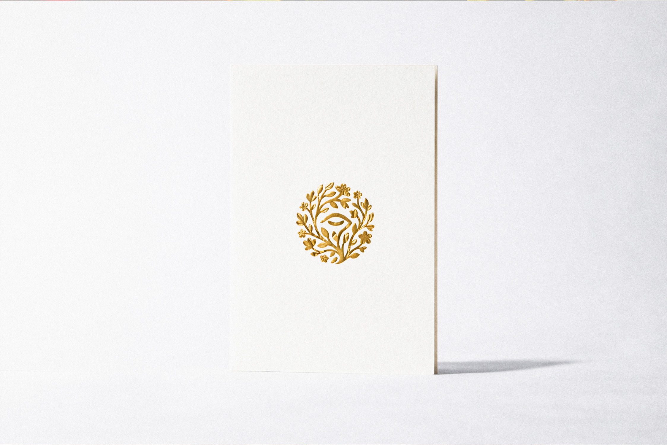 Reverie wellness brand identity gold emblem printed on stationery