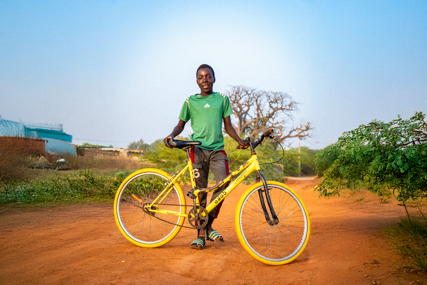 Student with yellow Baobike bicycle on rural road in Senegal