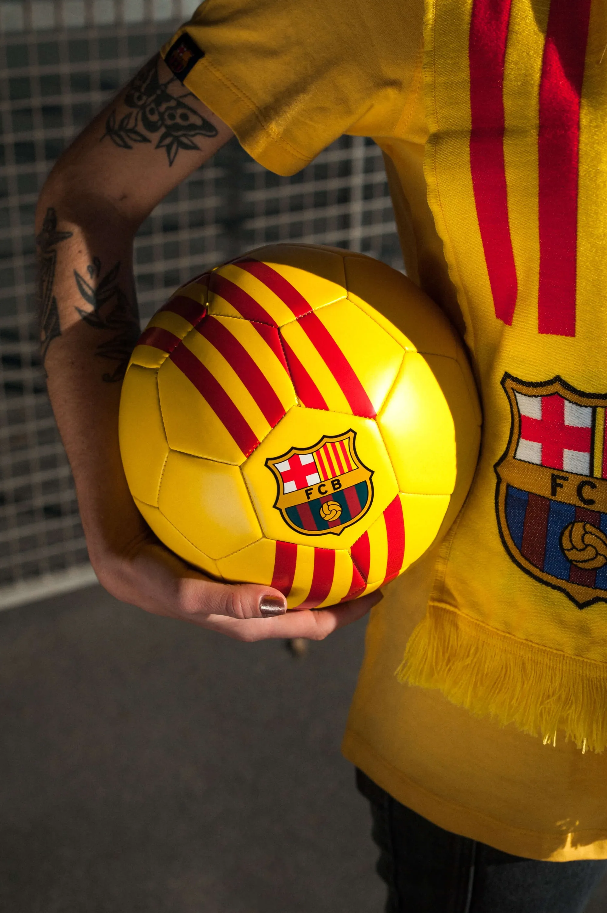 FC Barcelona supporter holding football with Catalan flag colours