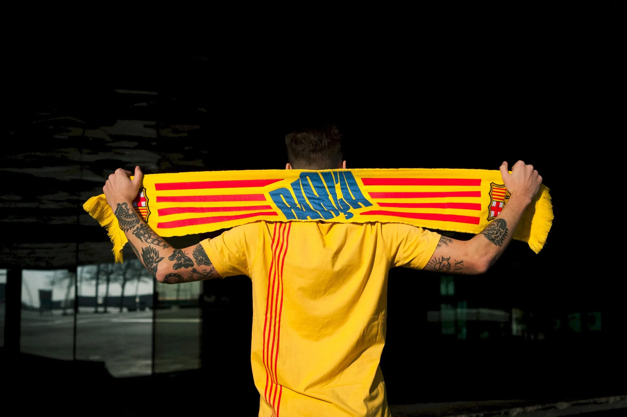 FC Barcelona supporter holding Catalan flag scarf celebrating football culture