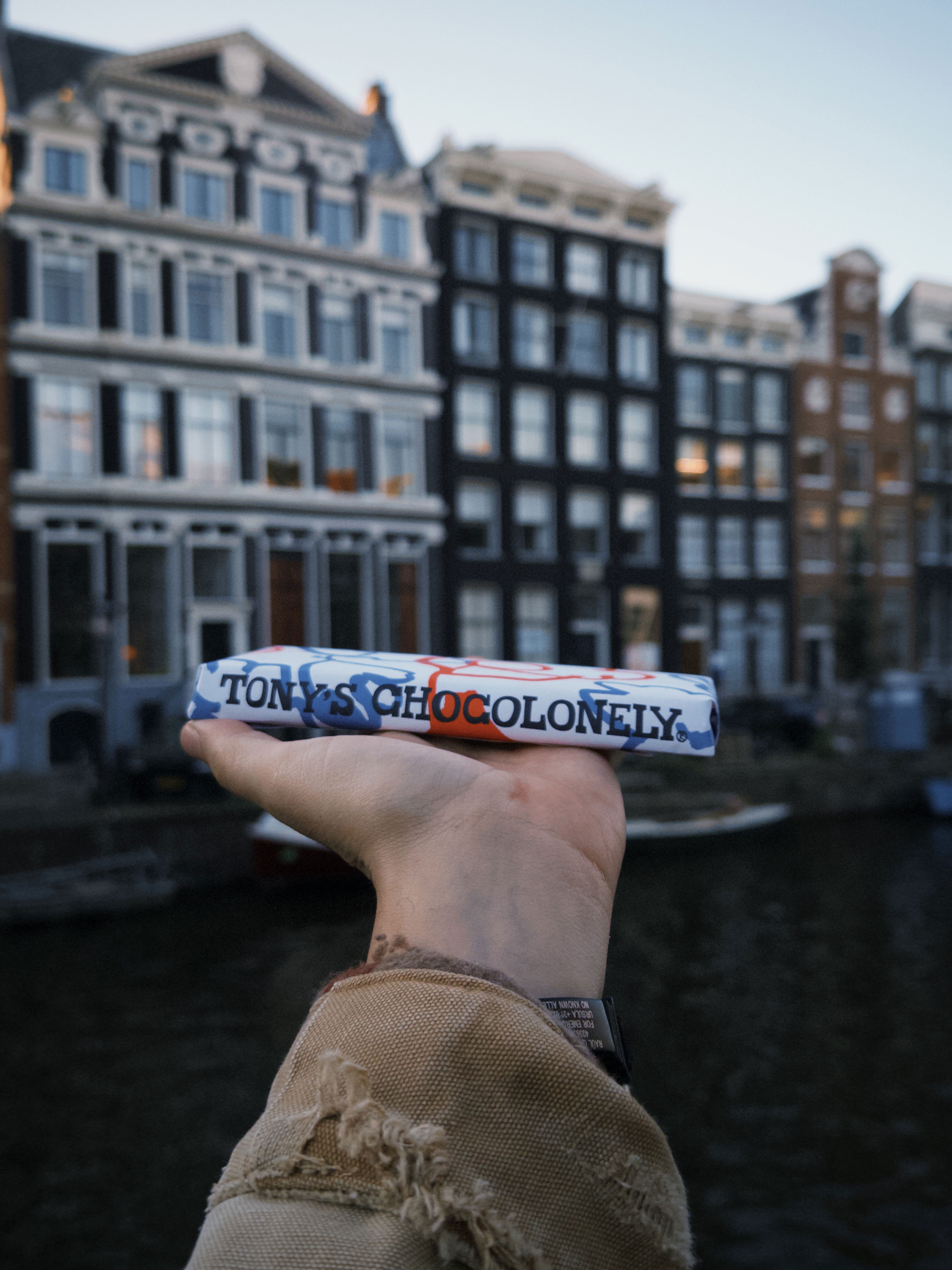 Tony’s Chocolonely chocolate bar close up, logo and wrapper design in urban Amsterdam setting