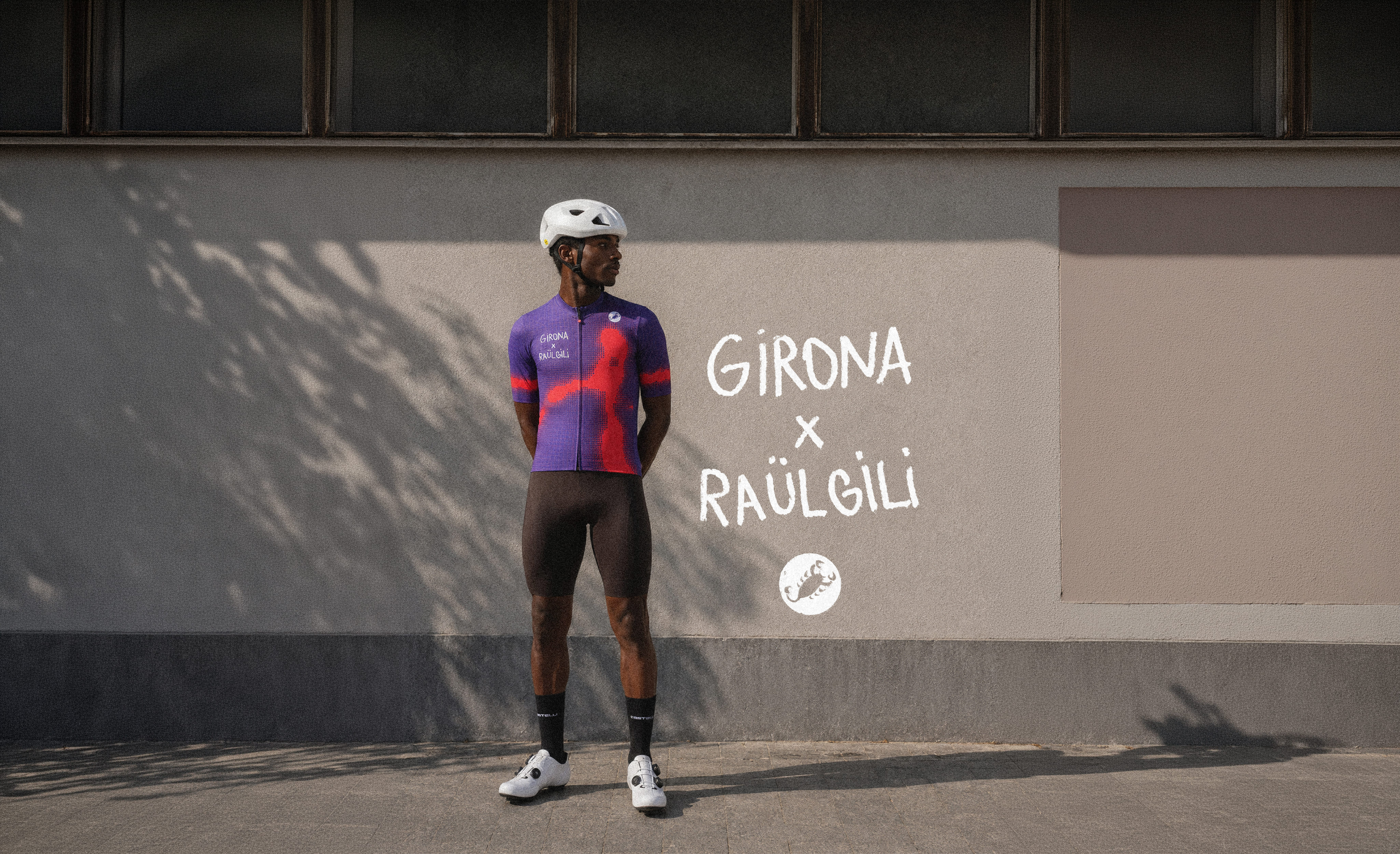 Cyclist wearing the purple and red Girona x Raül Gili jersey