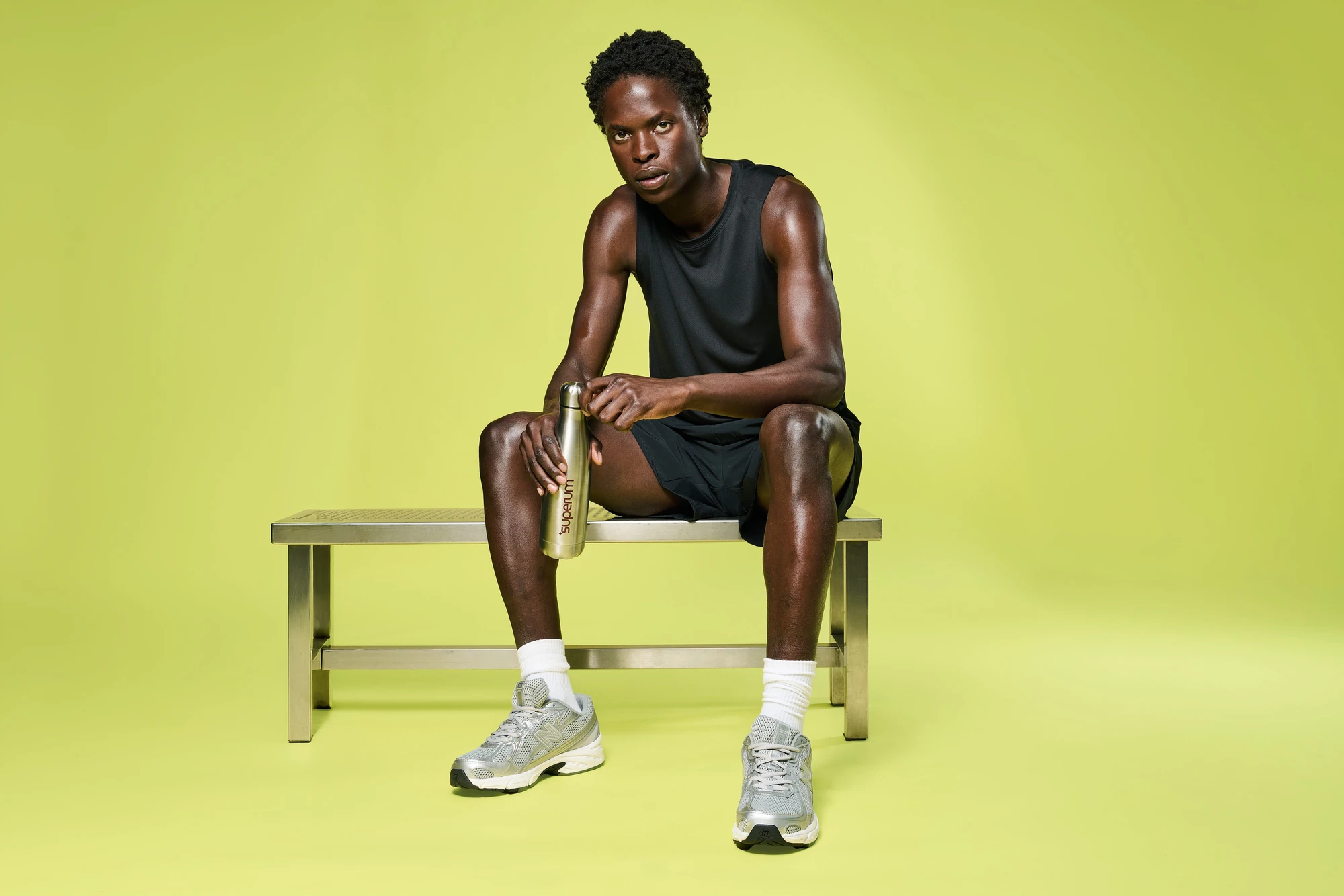 Kampagnenfotografie für Superum: Mann mit Trinkflasche im Fitnessstudio vor gelbem Hintergrund | Campaign photograpSuperum: man with water bottle in a gym setting against a yellow backdrop