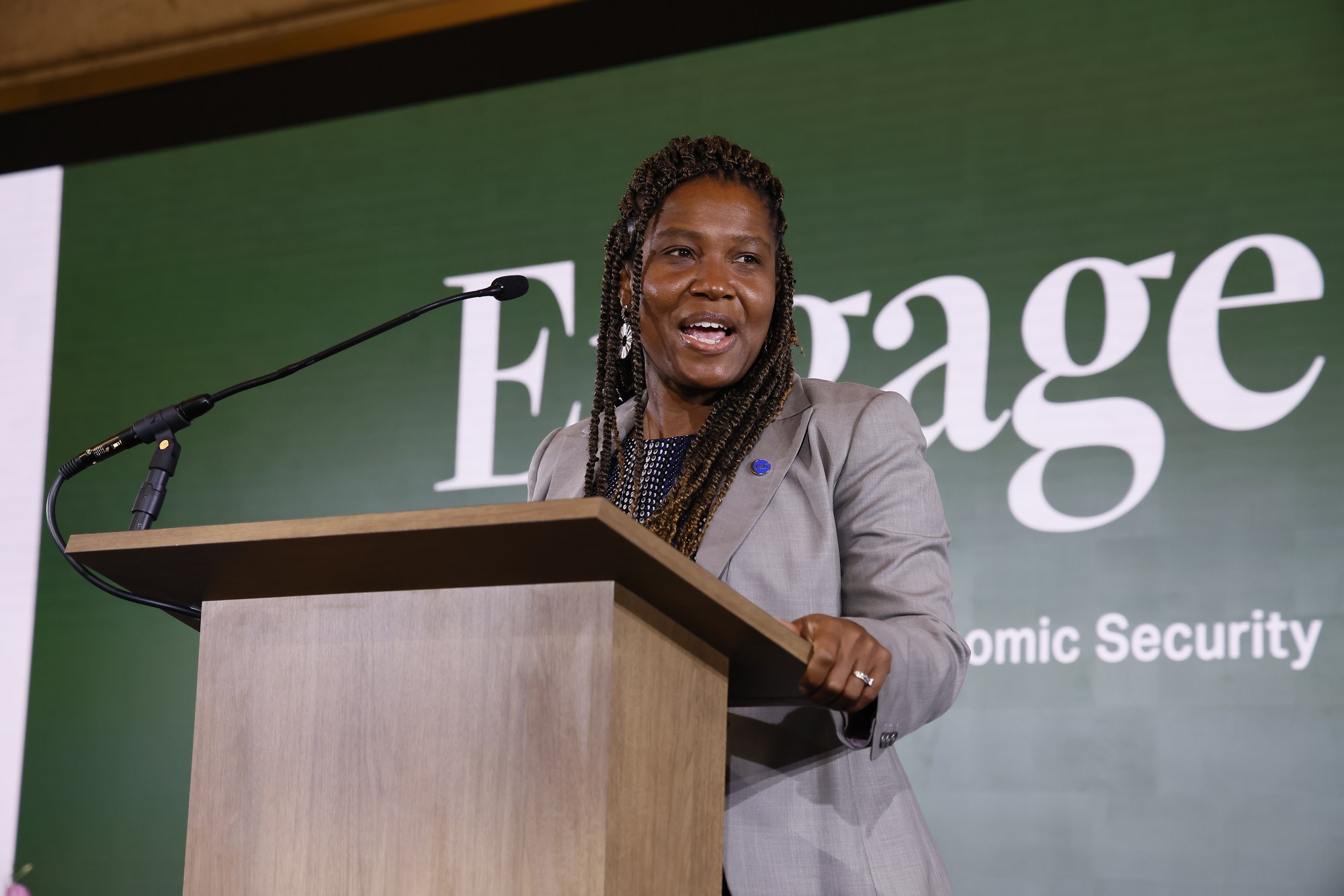 KaNeeTa Kimble speaking at a podium in front of the Engage backdrop