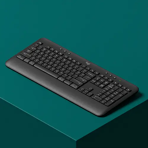 Wireless black Logitech keyboard on a dark teal surface.