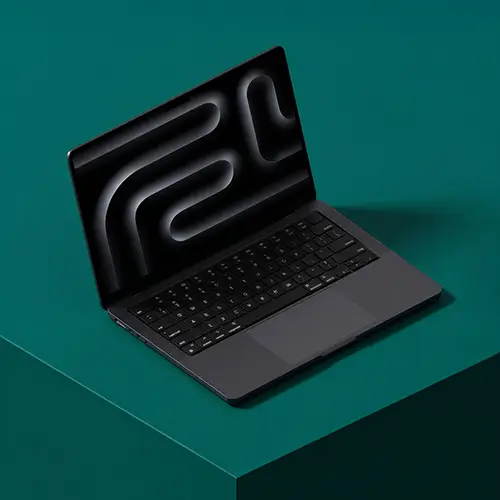 Modern black laptop with a minimalist abstract pattern on the screen, placed on a green surface.