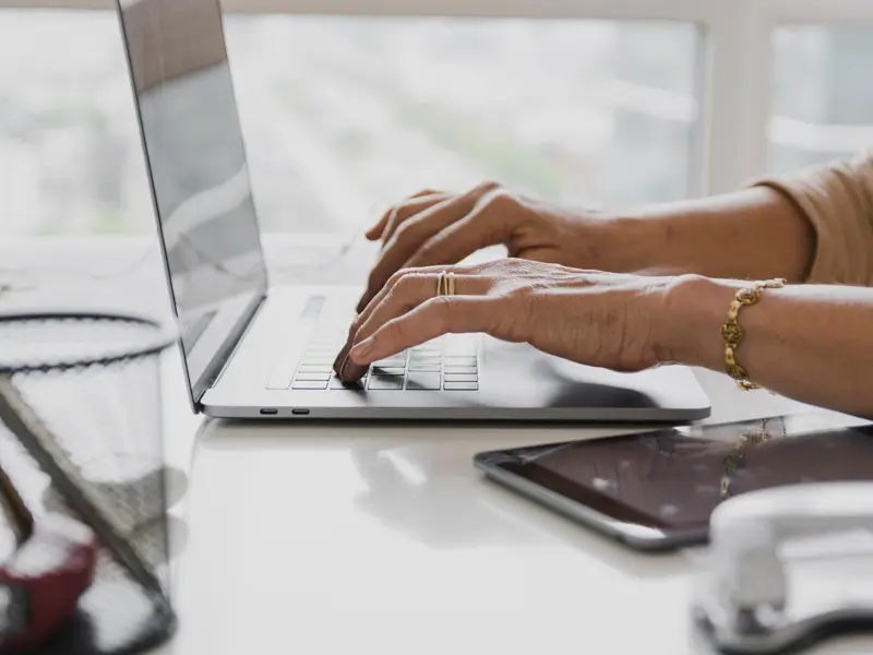 Business professional working on laptop managing HR operations through digital PEO platform solutions