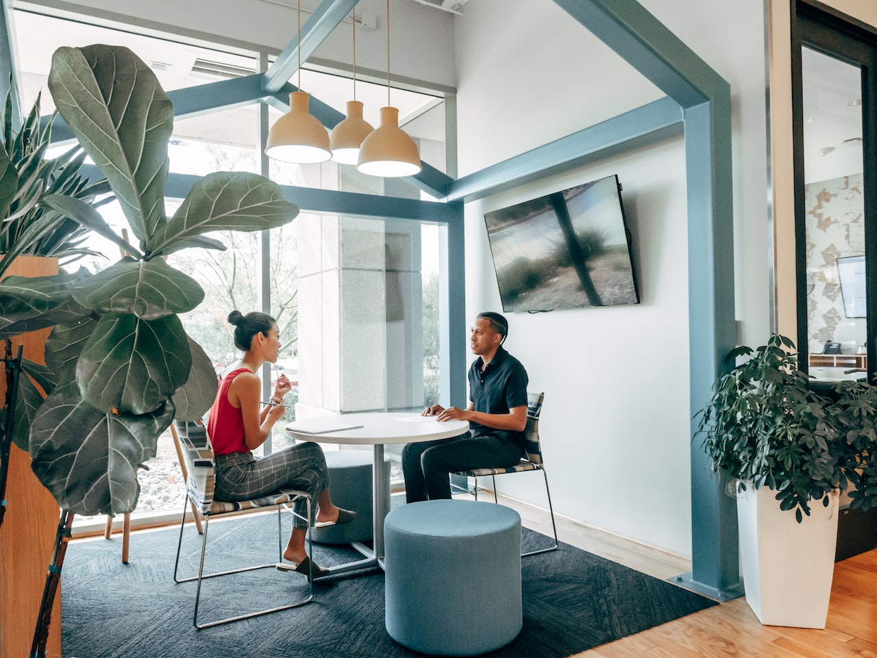 Two people having an in-person interview at a small round table in a modern office