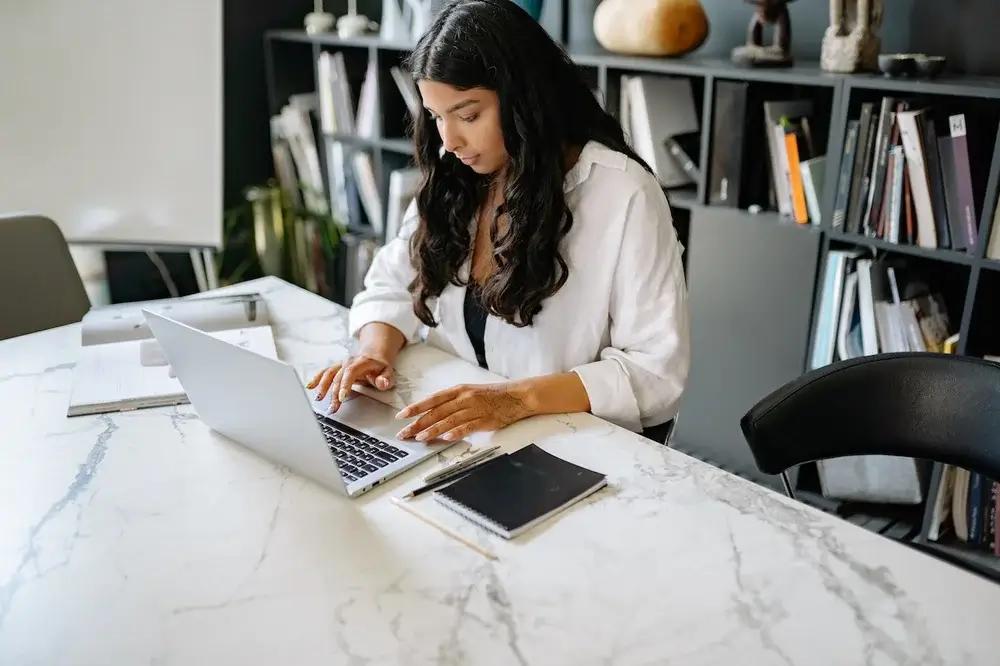 A woman types on her computer