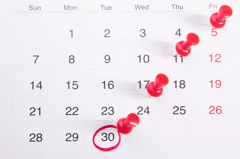 A calendar with red pins on important deadlines