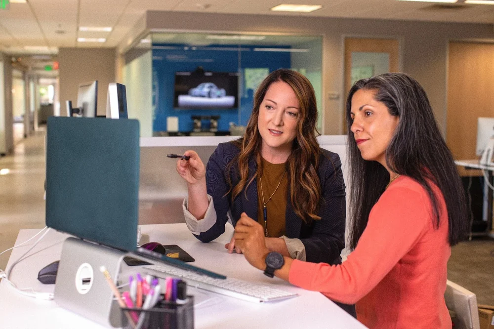 two women employees consulting a laptop