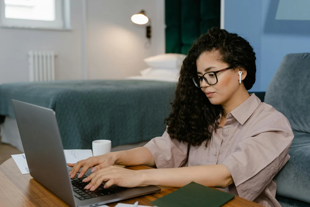 A young woman working on a laptop in her home