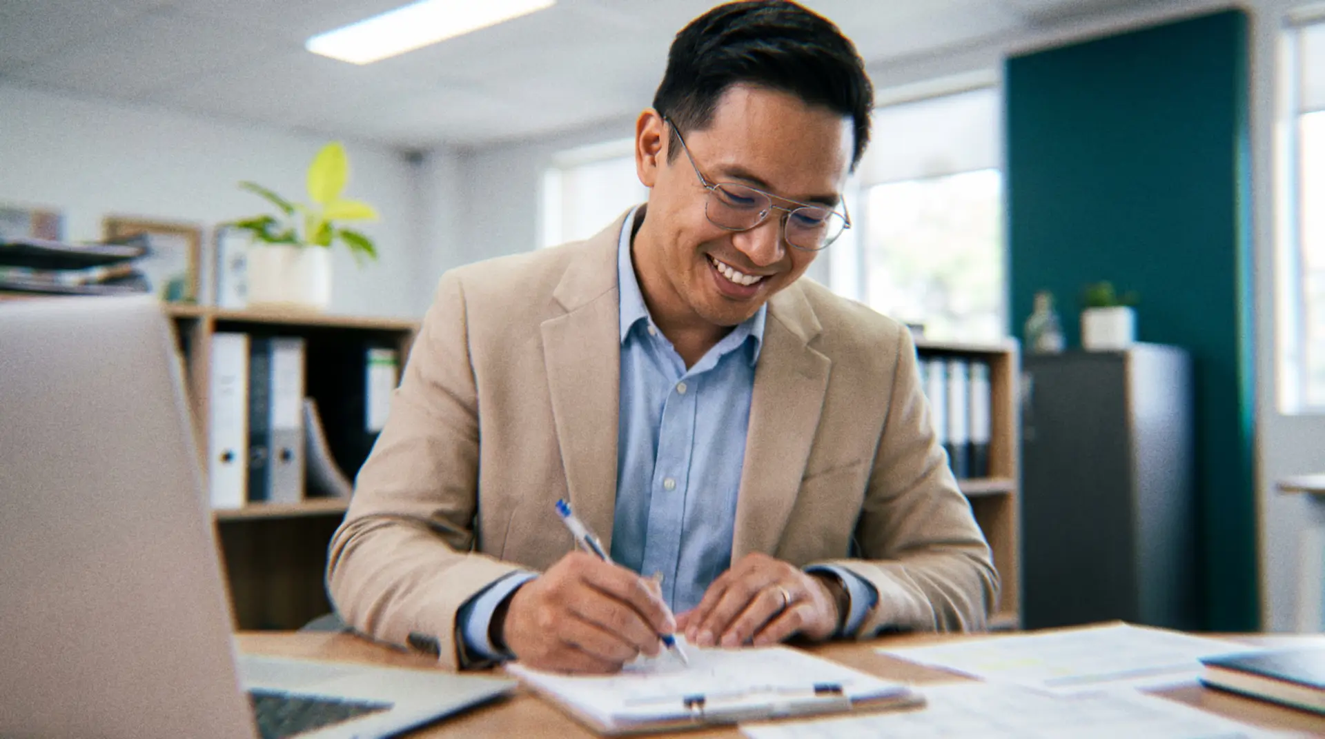 Smiling auditor reviewing CPA workpapers at his desk — offshore audit staffing solution for firms facing the CPA hiring crisis