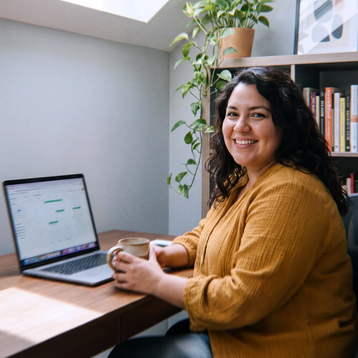 Colombian machine learning engineer smiling between video calls with U.S. meeting times on her laptop calendar