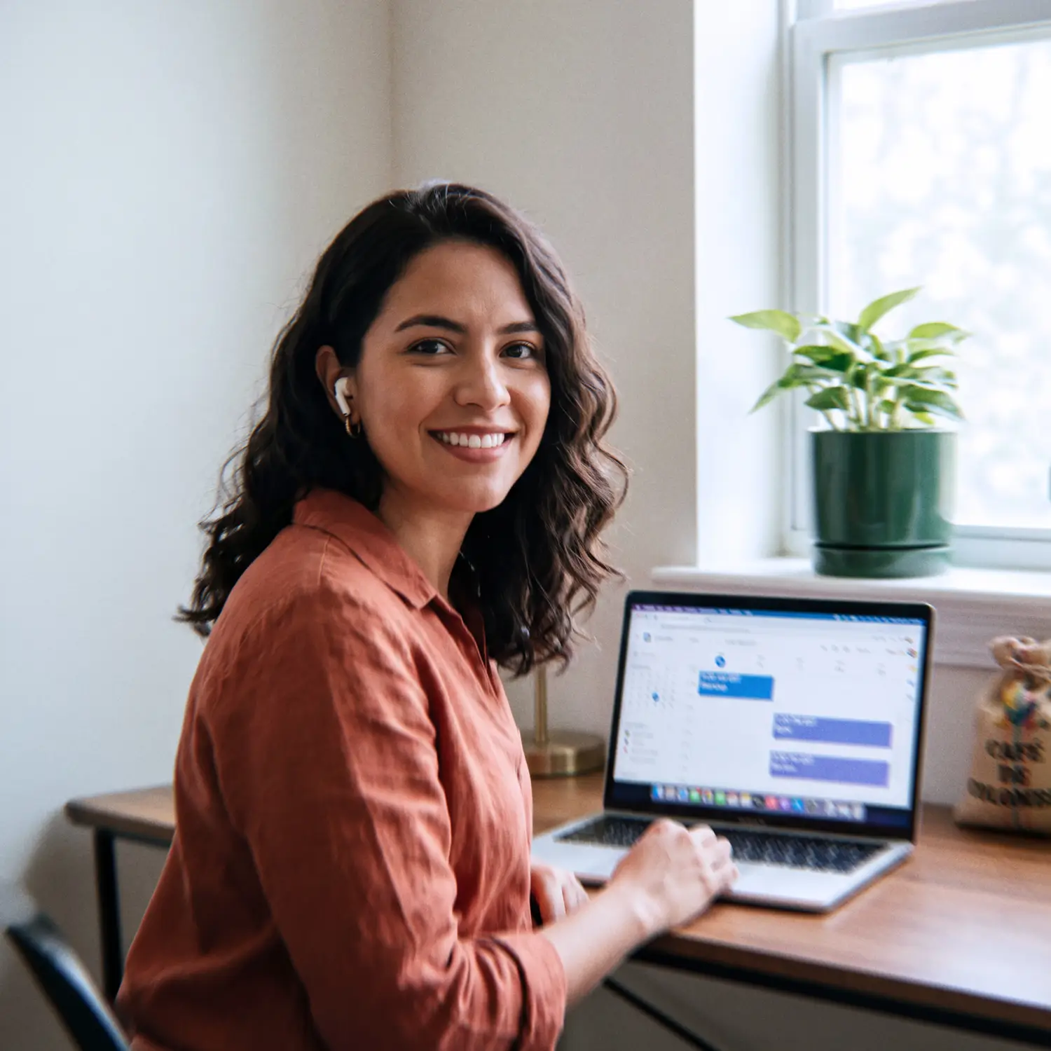 Colombian Generative AI Engineer smiling during a video standup with U.S. meeting times on her laptop calendar