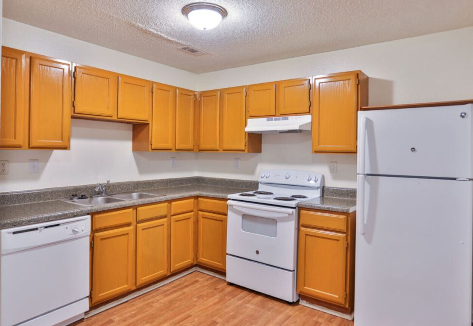 Kitchen with brown cabinets and white appliances