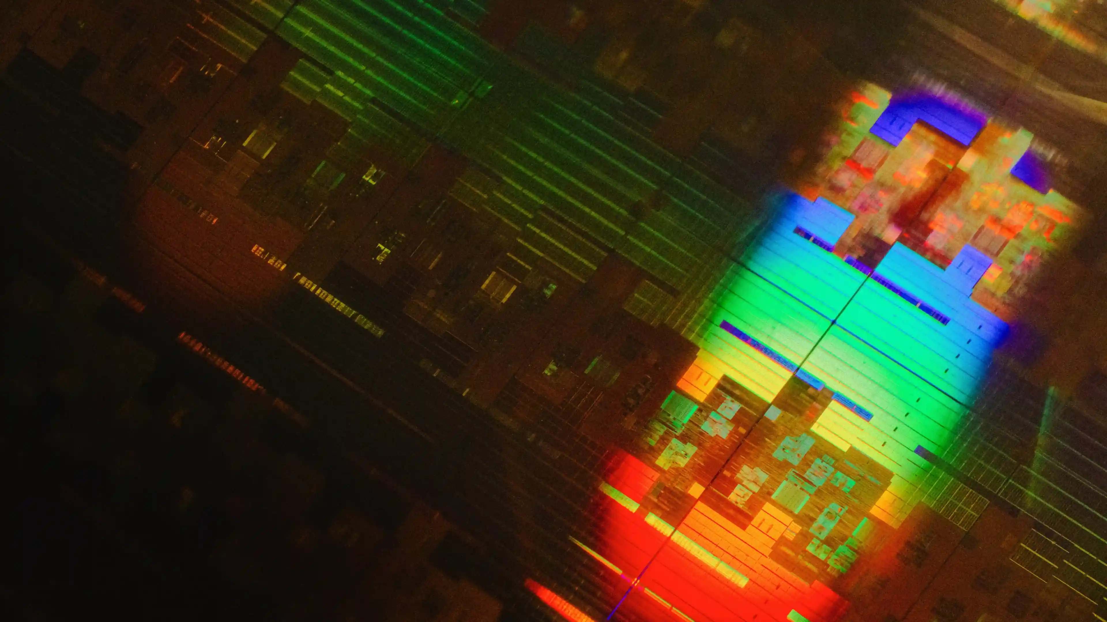 Close-up of a microchip circuit reflecting a spectrum of rainbow colors.