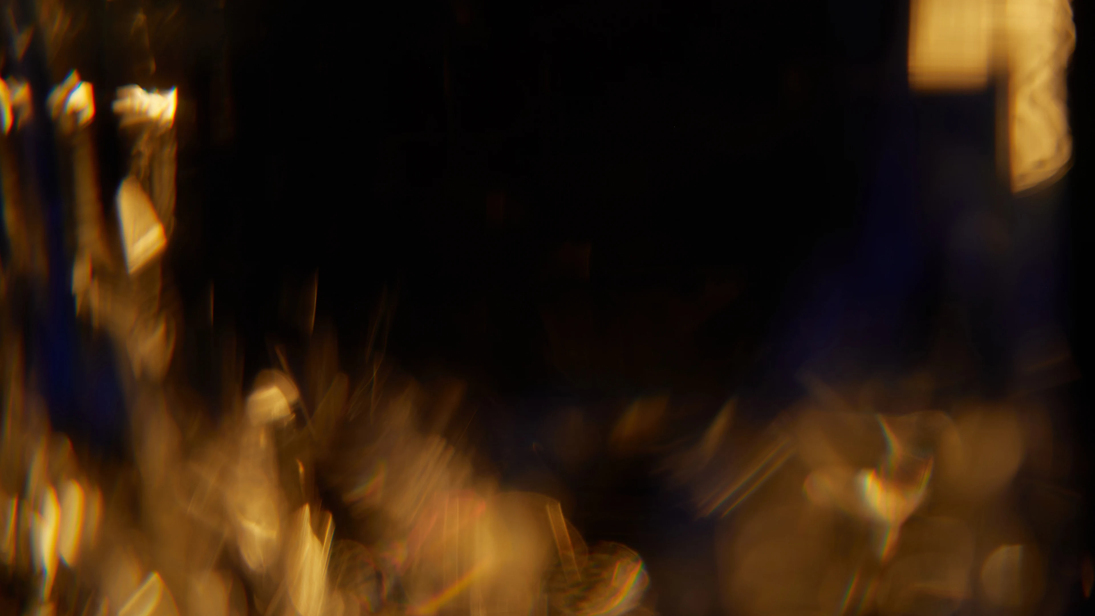 Close-up of golden bokeh lights with dark background creating an abstract effect.