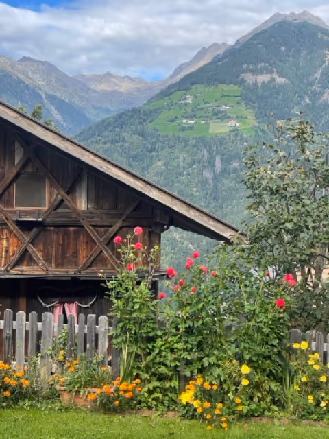 A beautiful picture of the Italian countryside with a wooden house overlooking mountains