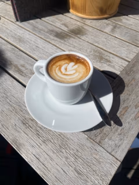 A cup of coffee with a nice design on top