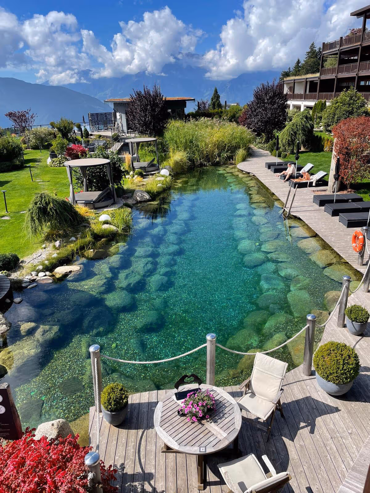 Luxurious outdoor setting with a stone pond and tables