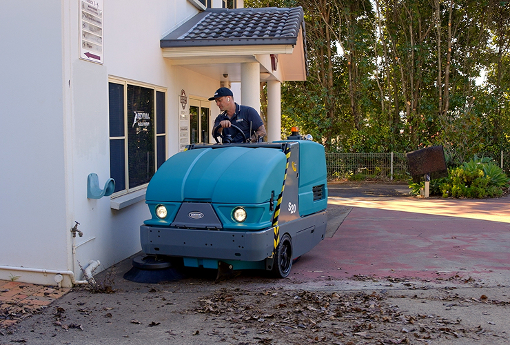 Industrial sweeping machine cleaning warehouse floor