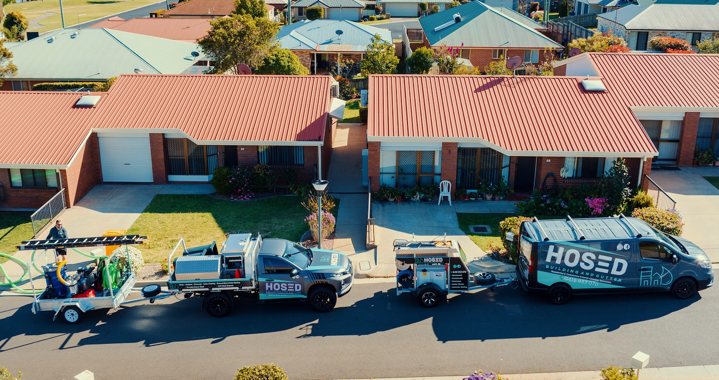 Hosed service vehicles and equipment parked outside Toowoomba family homes