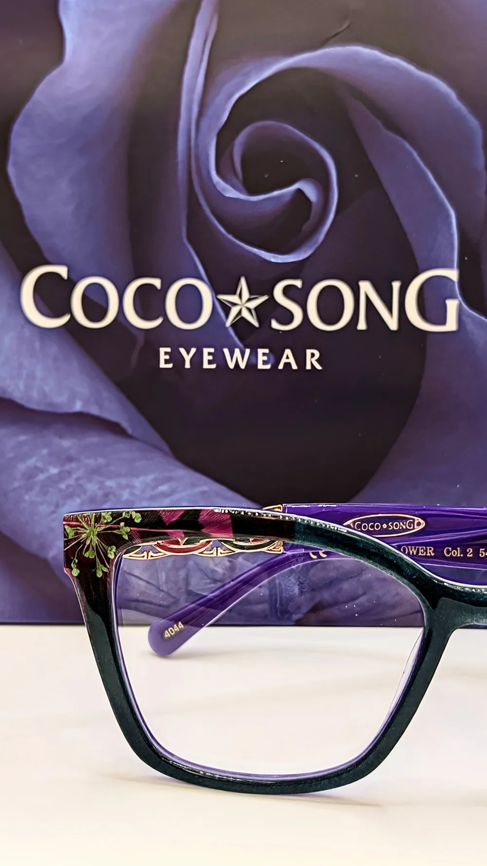 Coco Song glasses with ornate purple frames.