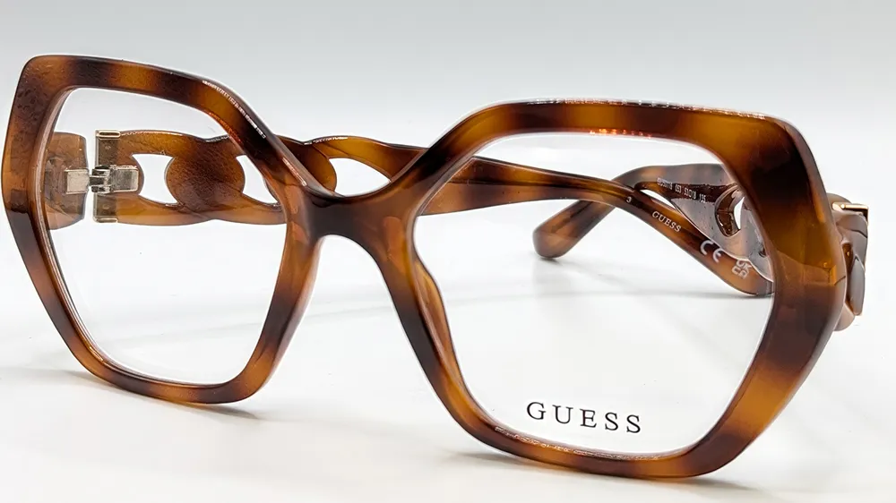 Guess glasses with bold geometric tortoiseshell frames and gold chain-link detail on the temples.