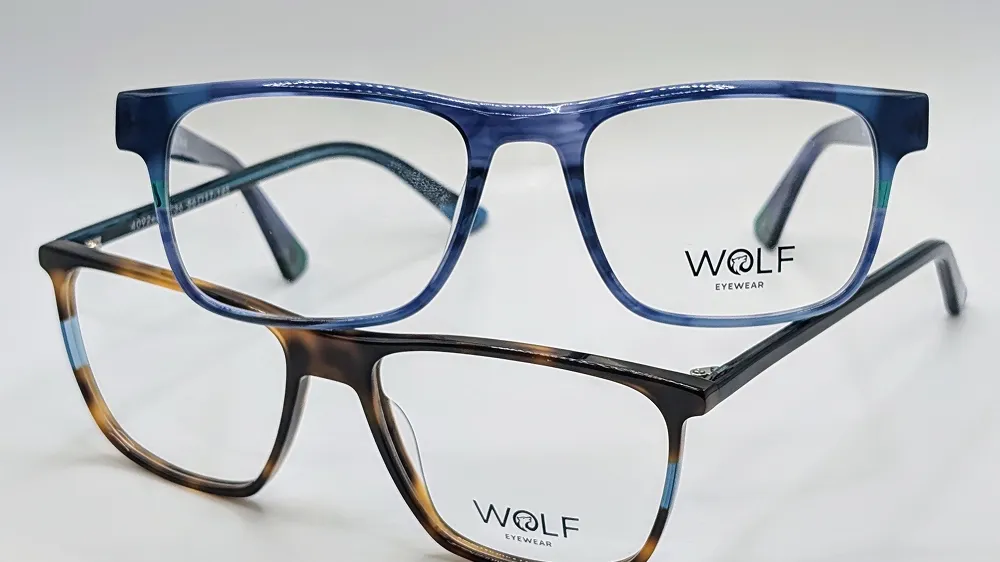 Two pairs of Wolf Eyewear glasses frames — one blue marbled, one tortoiseshell — displayed together.